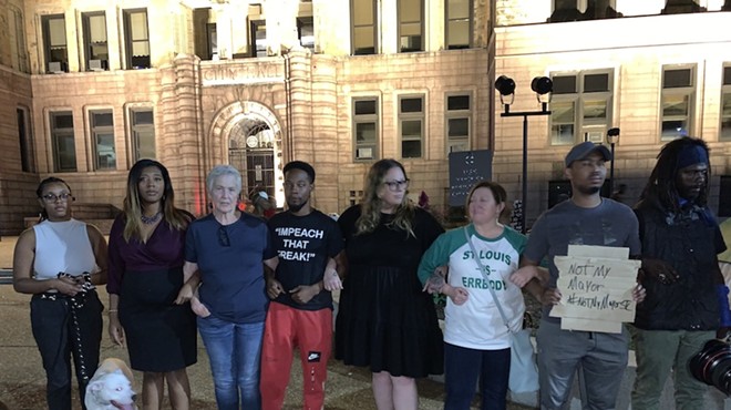 Advocates for homeless St. Louisans, including both current and former aldermen, link arms outside City Hall to oppose a planned camp dispersal.