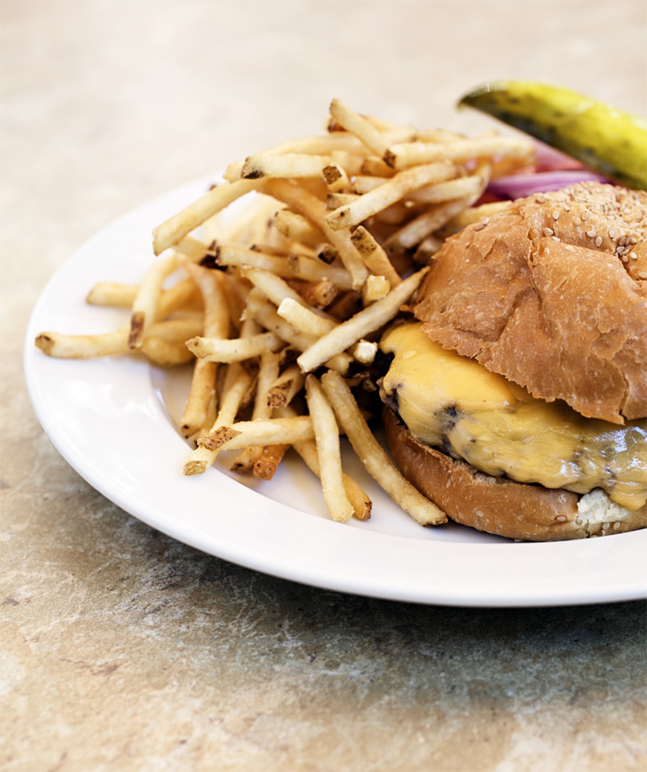 Chef Dave's Griddle Burger is a 1/2 lb griddle seared sirloin served with lettuce, tomato, onion and shown here with American cheese and fries.