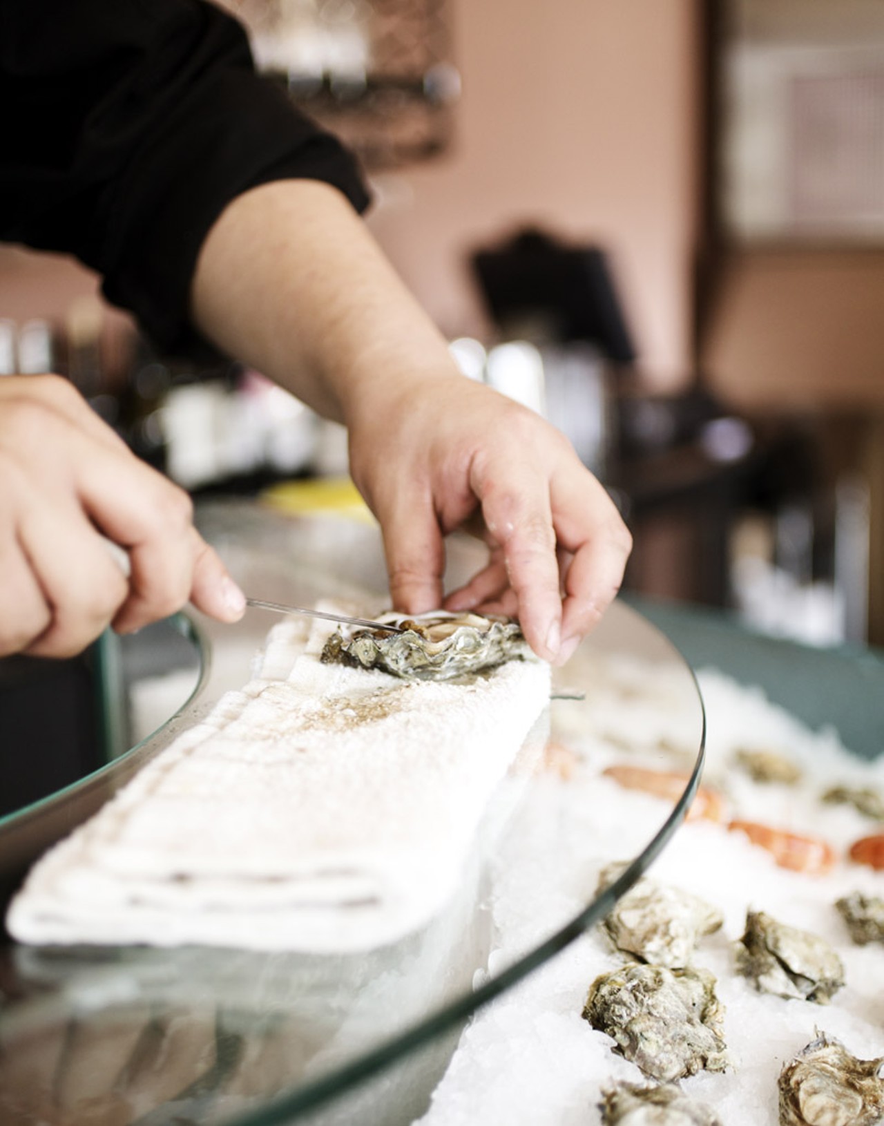 Chef Je Kang shucking oysters.