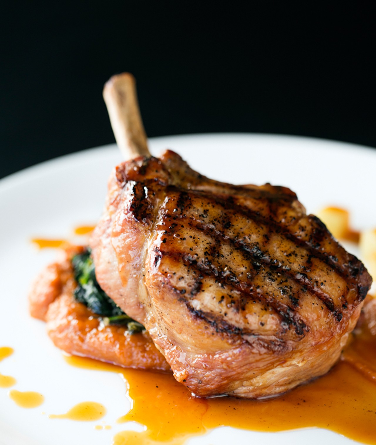 The smoked pork chop is cold smoked with apple and cherry wood, served with cider sauce, compressed apples, spinach and sweet-potato puree.
