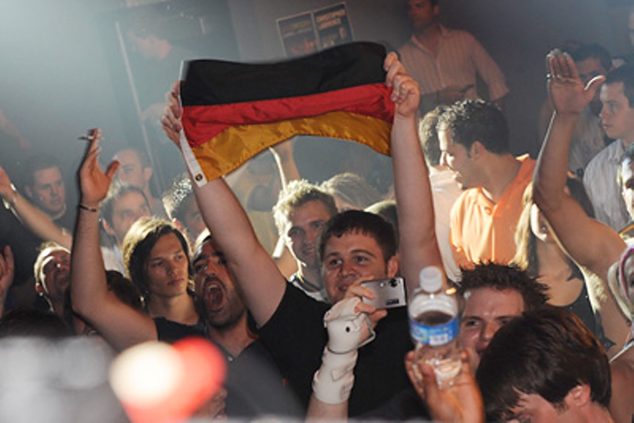 A fan holds up a flag from Paul van Dyk's native country of Germany during the DJ's performance.