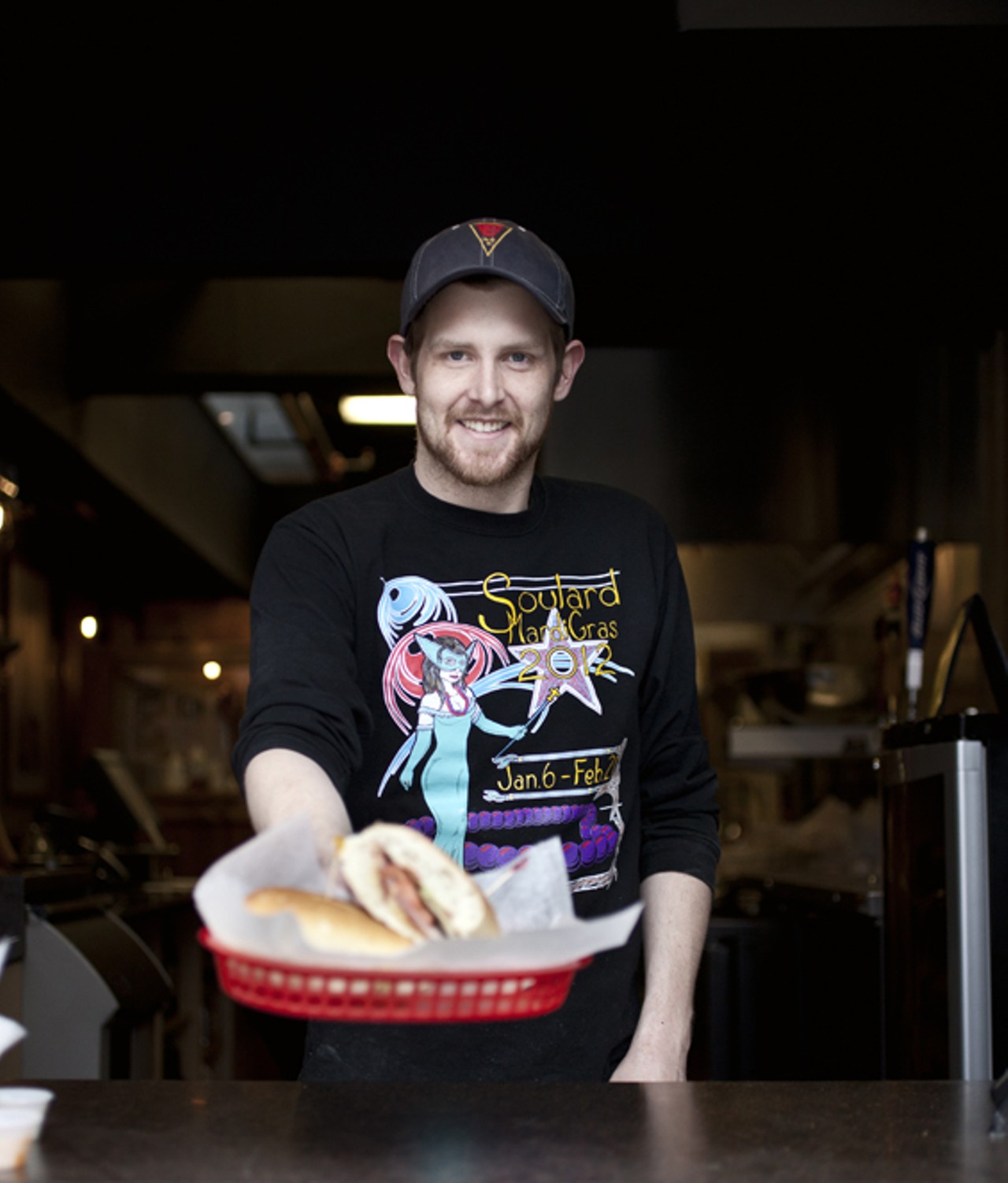 Chef and pizza maker Taylor Hagglund serving a "The Hill Sub" through the store's front window.