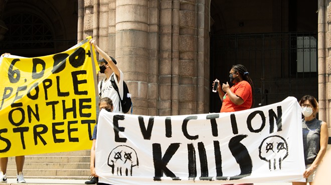 Protesters hold up banners outside City Hall on August 2, 2021.