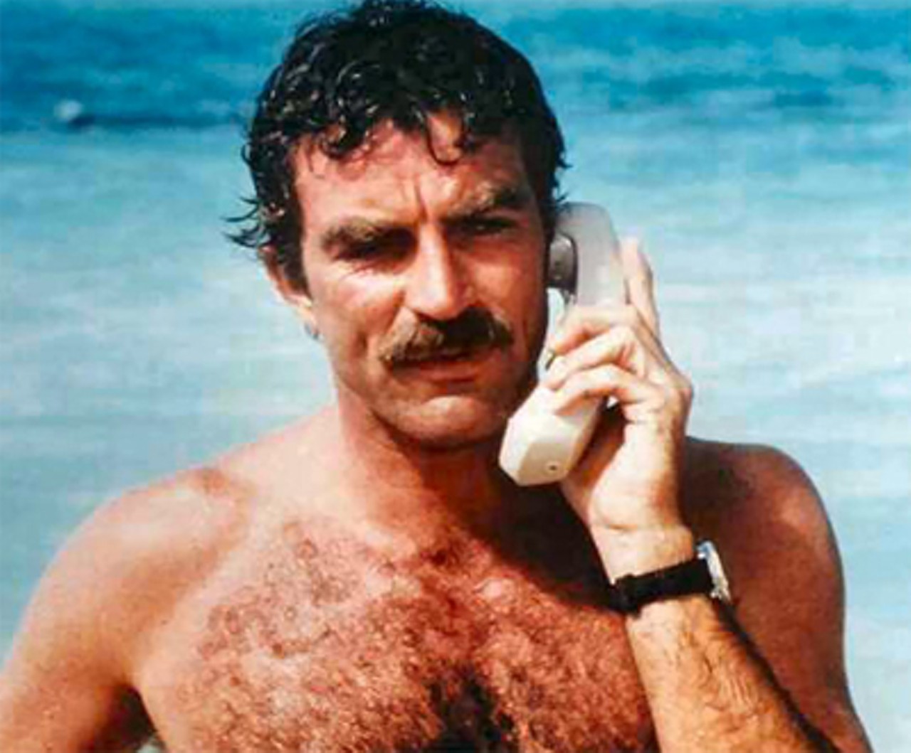 Tom Selleck and his mustache talk on a phone. On the beach. This clearly isn't a cell phone either. Weird.