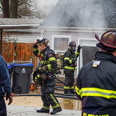 A firefighter removes his mask after exiting a burning house on Friday, Jan. 26, 2024, in Florissant.