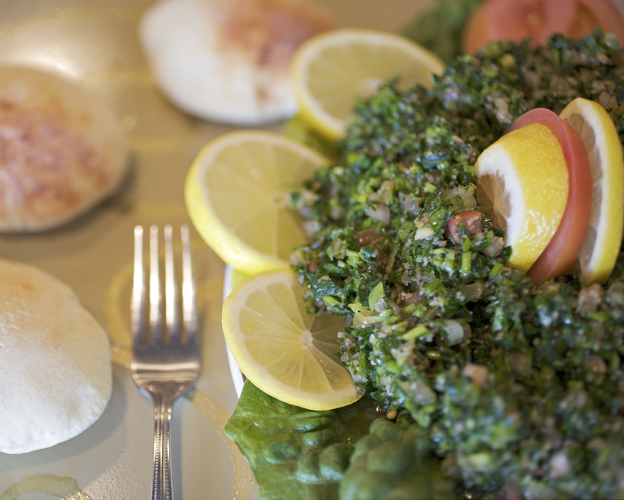Tabbouleh, a salad dish, is comprised of parsley, tomatoes, green onion, bulgar wheat, lemon juice and olive oil.