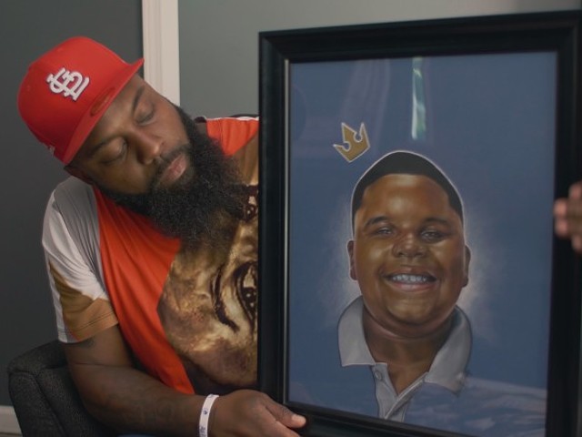 Michael Brown Sr. with a portrait of his son in a scene from Ferguson Rises.