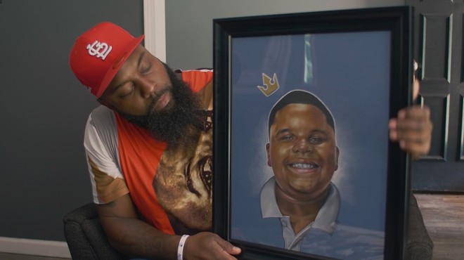 Michael Brown Sr. with a portrait of his son in a scene from Ferguson Rises.