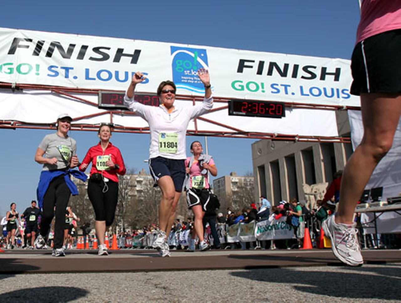 Deborah Siewing throws her hands up with joy for finishing the half marathon.