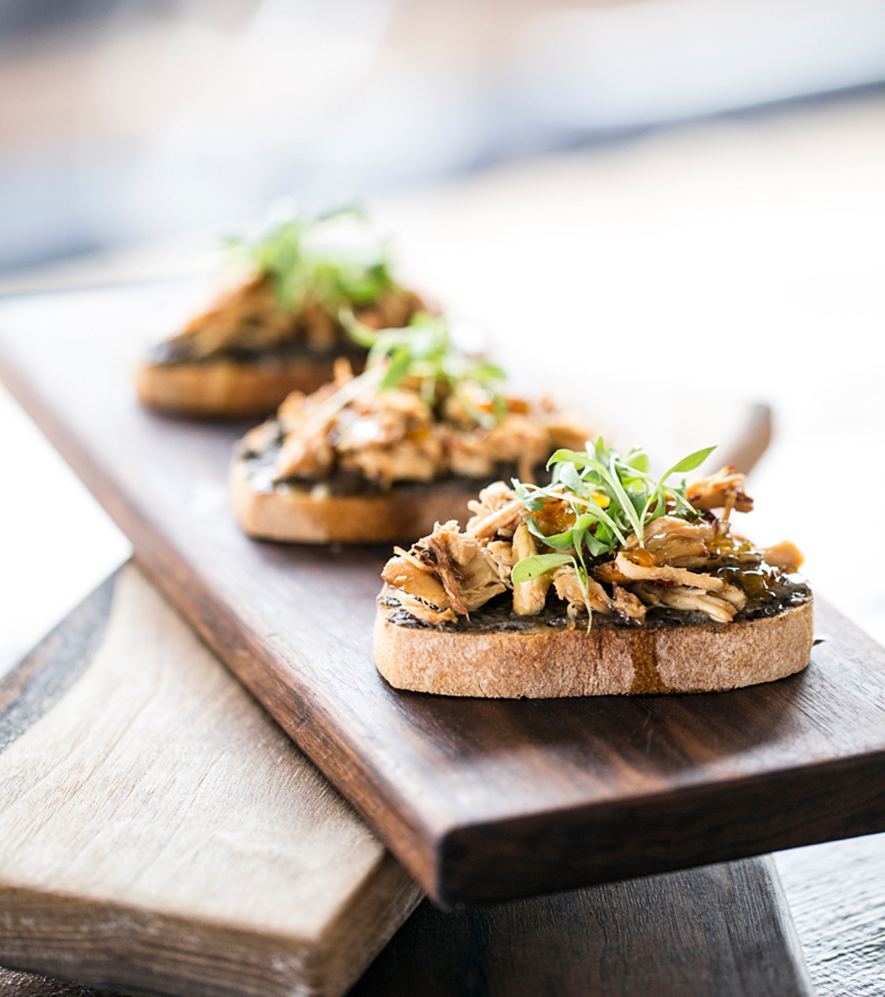 Bruschetta is topped with melted Marcoot "Tipsy" cheddar, black bean spread, Buttonwood Farms chicken, Double Star Farm hot pepper jelly and micro cilantro.