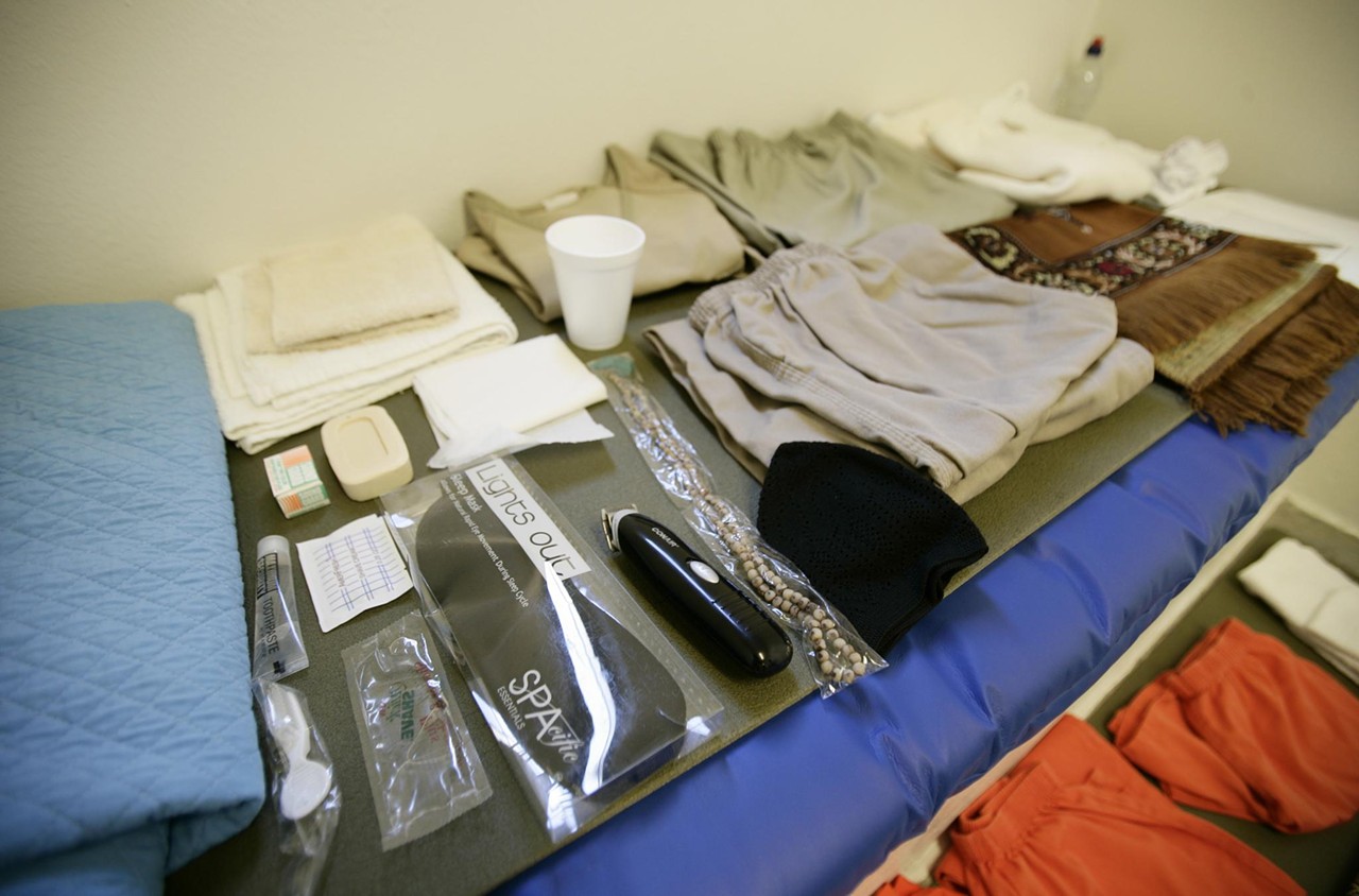 An assortment of items every detainee receives: hygiene products, cotton jumpsuits, and a prayer rug.