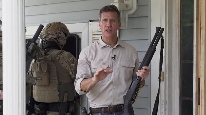 Eric Greitens and a paramilitary goon squad prepare to break into an empty house for some reason.
