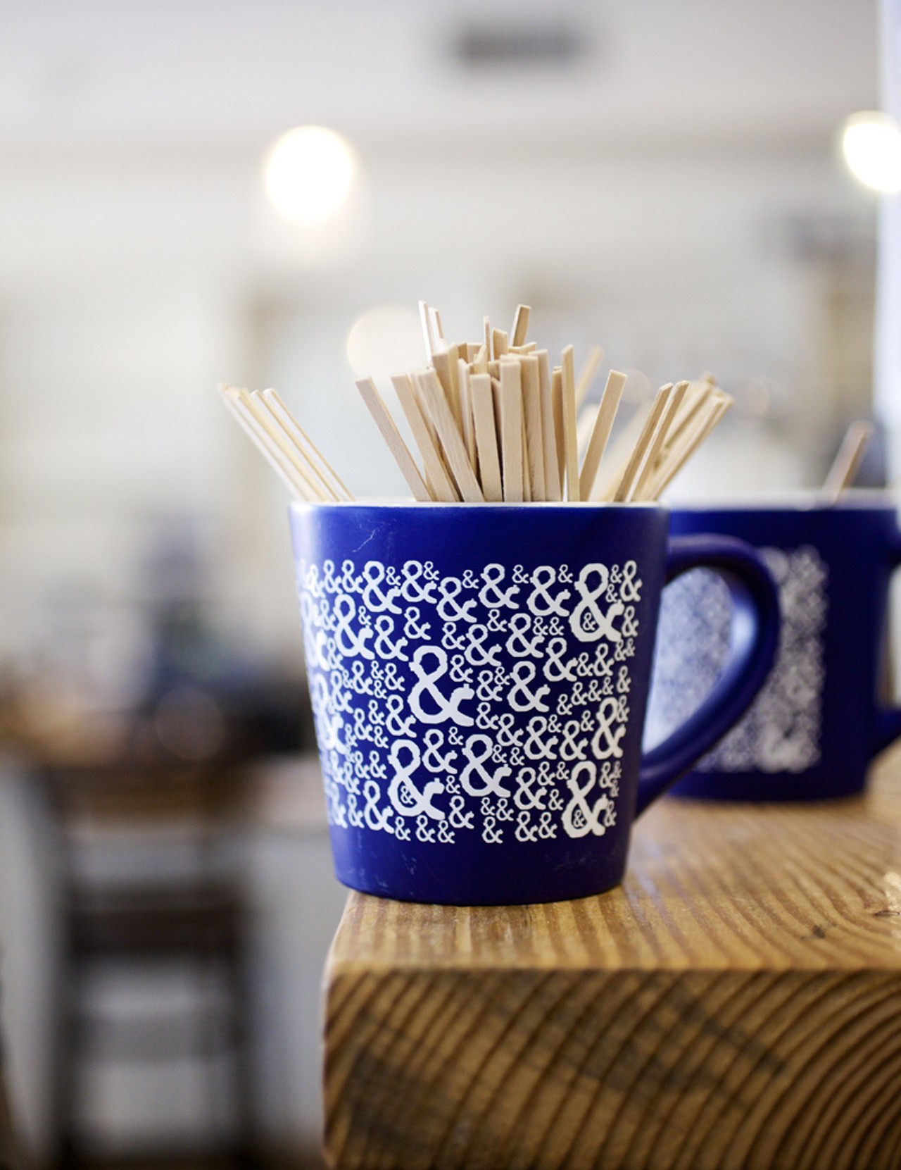 Coffee stirrers in the restaurants signature coffee mugs.