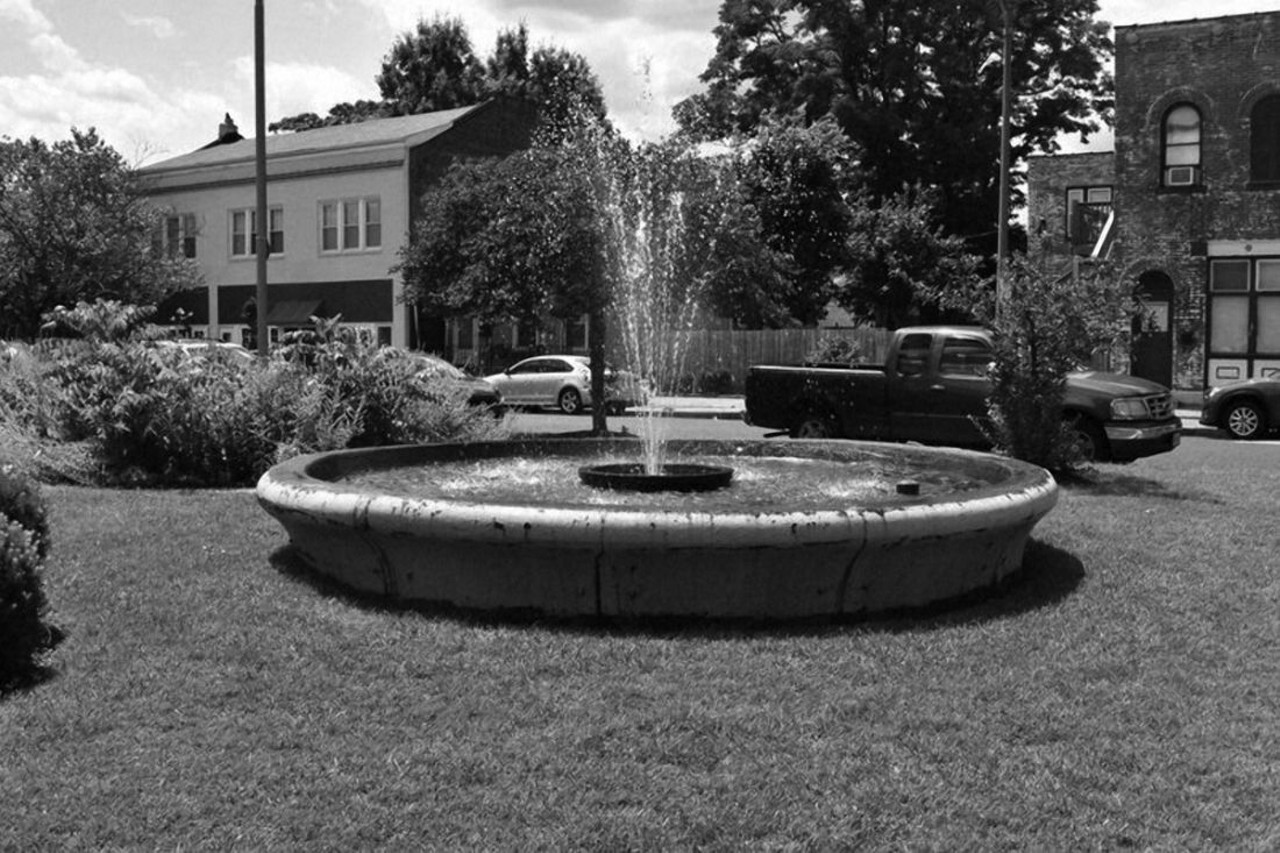 This Used to Be: a trough to water horses
Now It's: a water fountain
Location: the Ivory Triangle
"The streets meet at angles forming Wedge-shaped blocks in the Ivory Triangle, the historic German area of South City's Carondelet Neighborhood. The focal point is a triangular block framed by Ivory Avenue, Virginia Avenue, and Schirmer Street that serves as a commemorative park. It includes a flagpole and a bust of neighborhood leader Albert 'Red' Villa. The son of Italian immigrants, Villa served as alderman for the Carondelet neighborhood from 1953 to 1990. During the late nineteenth century, this iron pool served as a trough to water horses."
"The water fountain in Carondelet's Ivory Triangle." Image courtesy of Emma Prince.