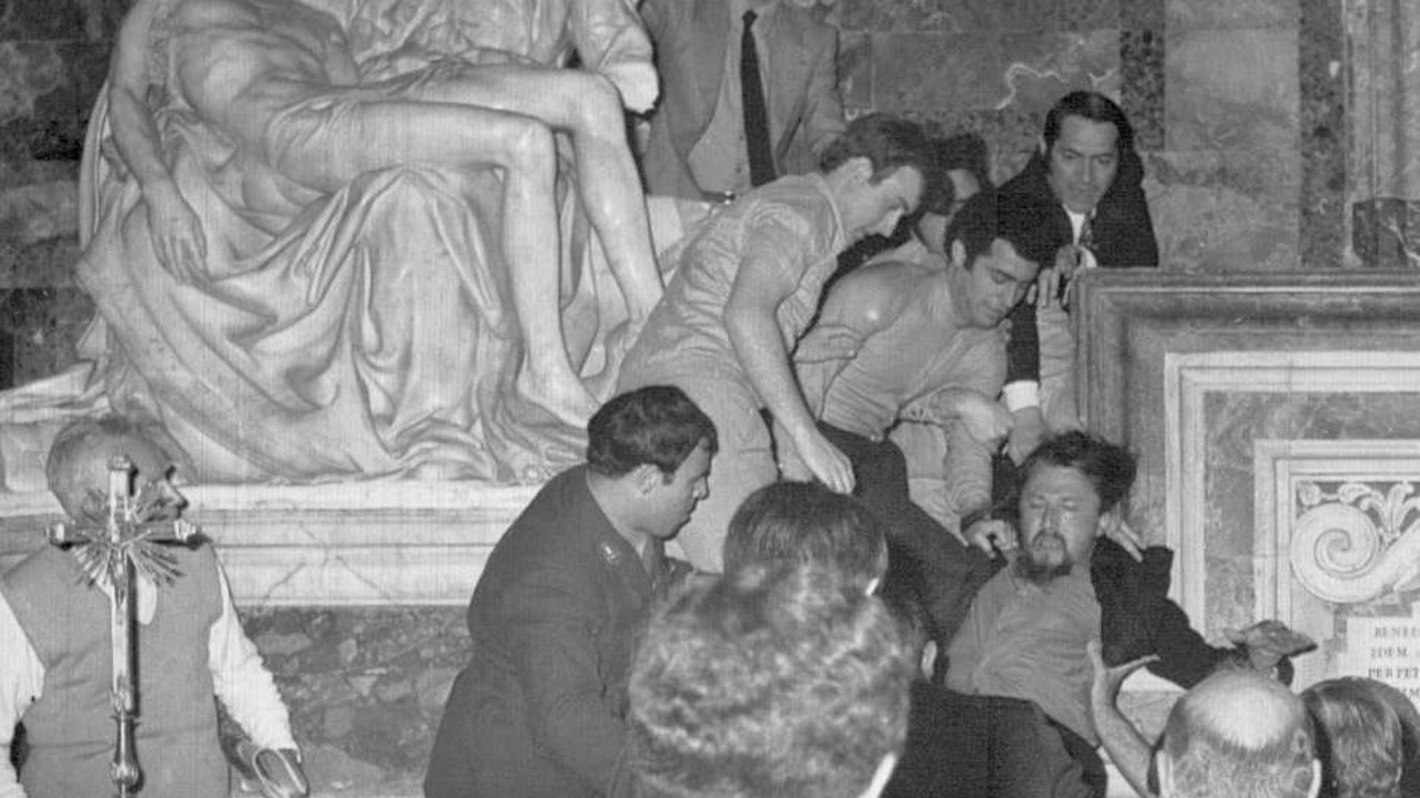 Bystanders drag Laszlo Toth (right) away from the Pieta in St. Peters after he smashed it with a hammer. This photo was released by the Vatican the following day.