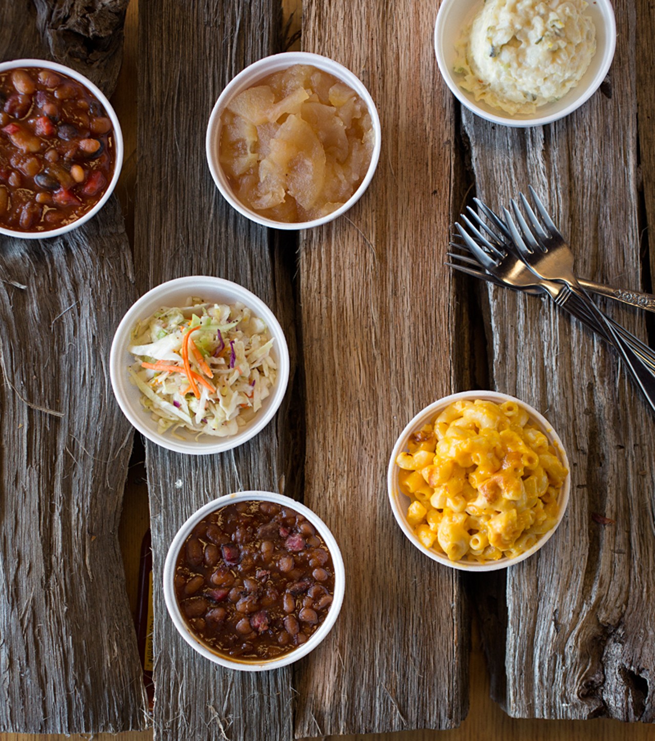 Sides from top left: baked beans, warm apple sauce, baked-potato salad, mac & cheese, sweet brisket beans and crispy cole slaw.
