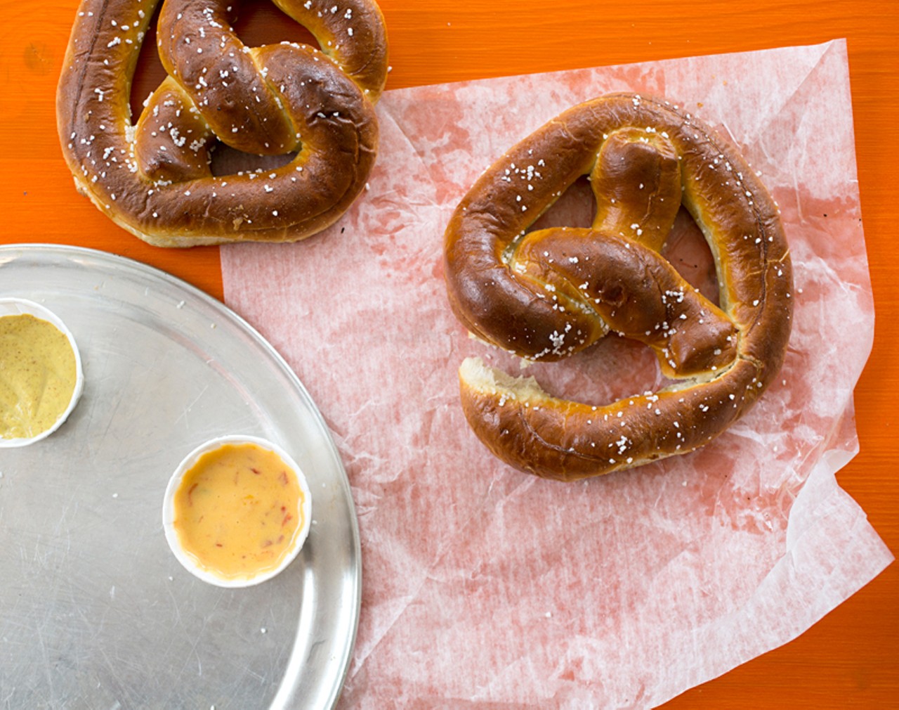 Two big soft pretzels. Buttered, salted, and toasted with dipping sauces.