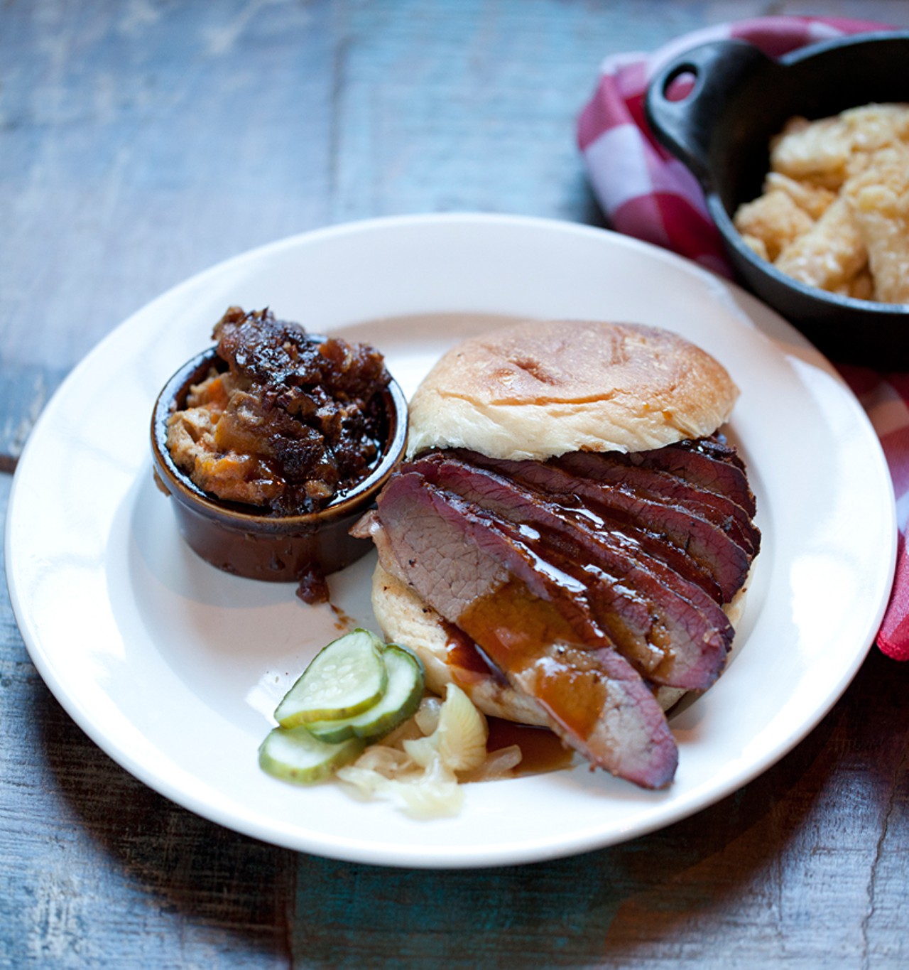 The smoked-brisket sandwich is served with housemade pickles and onion marmalade. It's shown here with sides of sweet-potato casserole and macaroni & cheese.