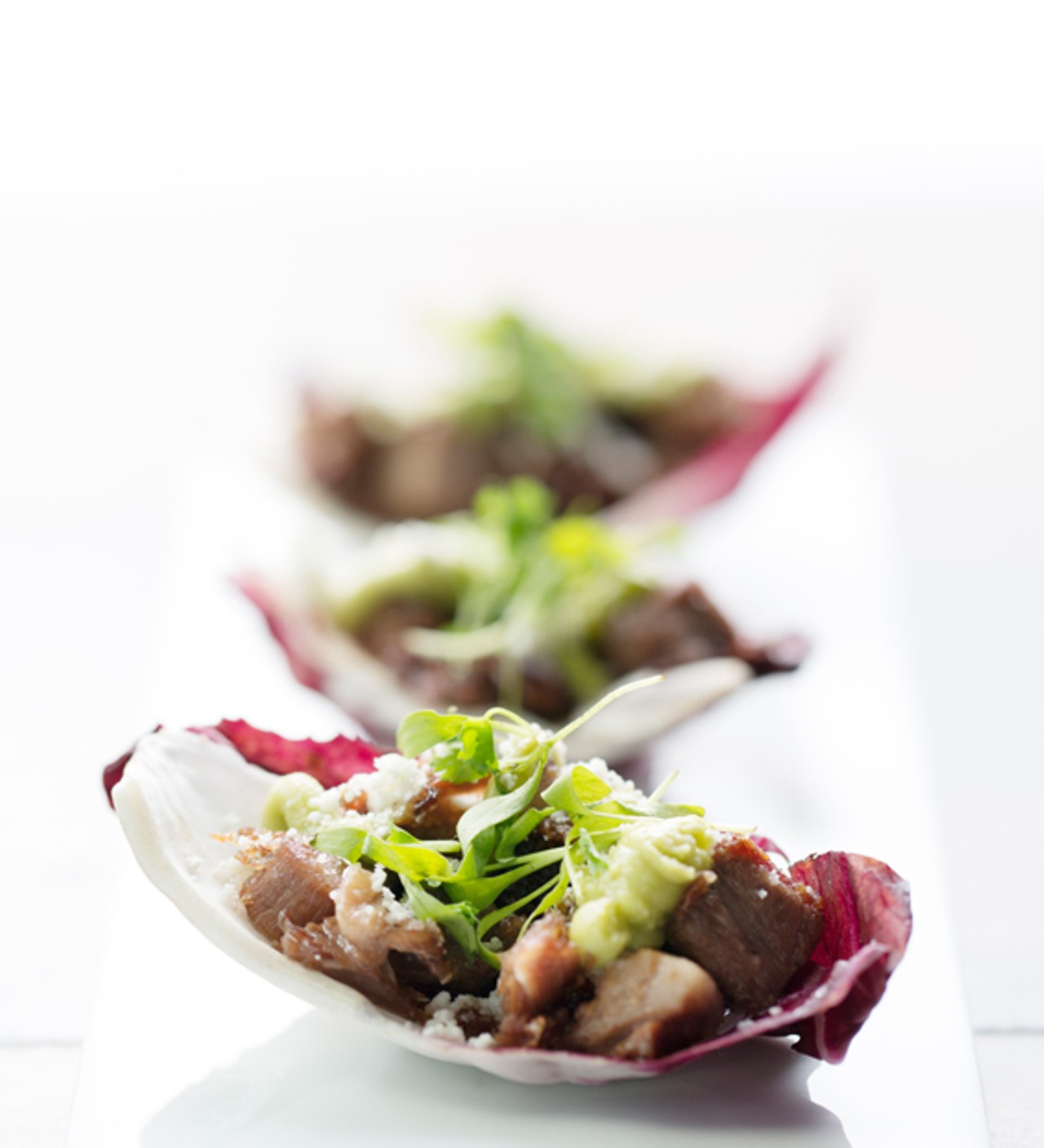 The crispy beef tongue is served with radicchio, fresh cheese, cilantro and avocado cream.