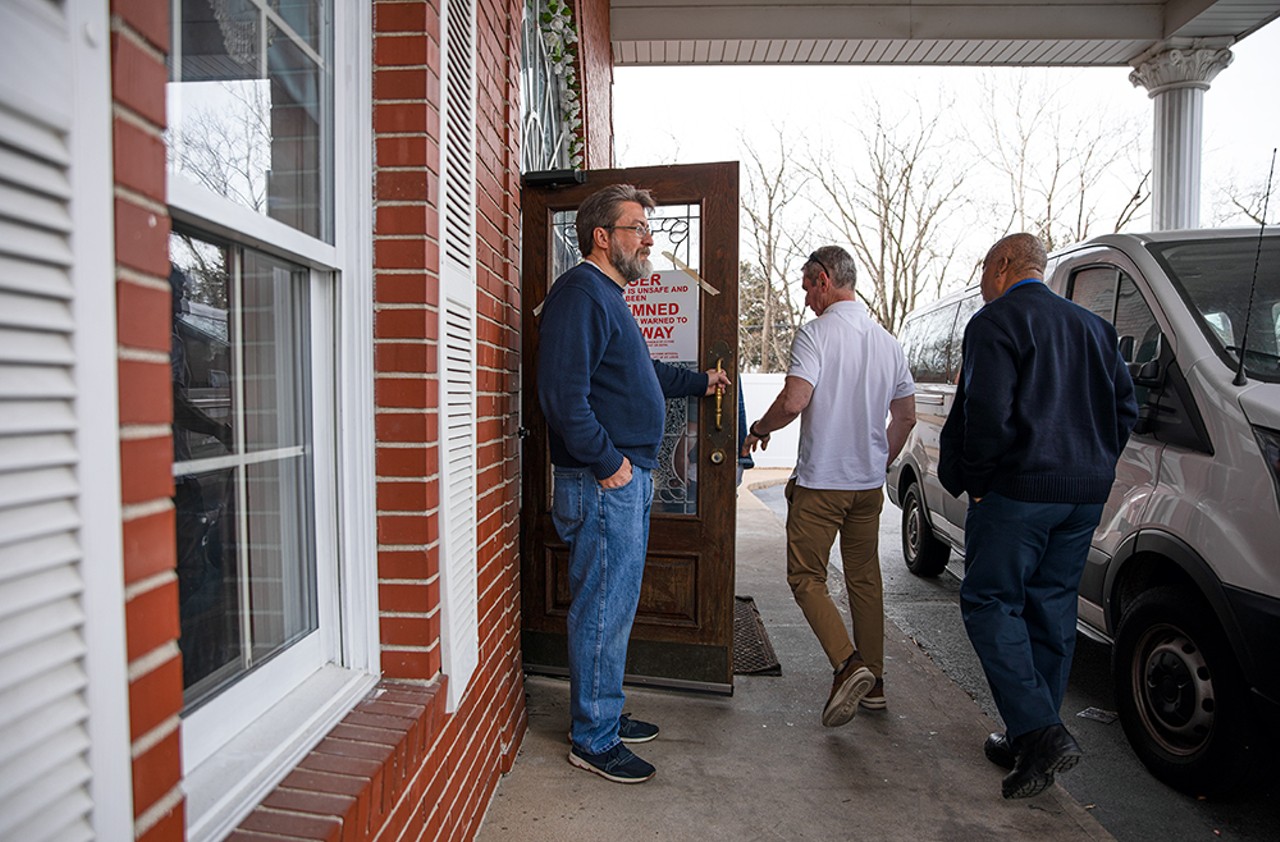 The church building's former owner, Reverend Arlie Singleton, left, holds the door while code enforcers with the City of St. Louis enter Mount Of Olives Ministry on Tuesday, March 5, 2024.