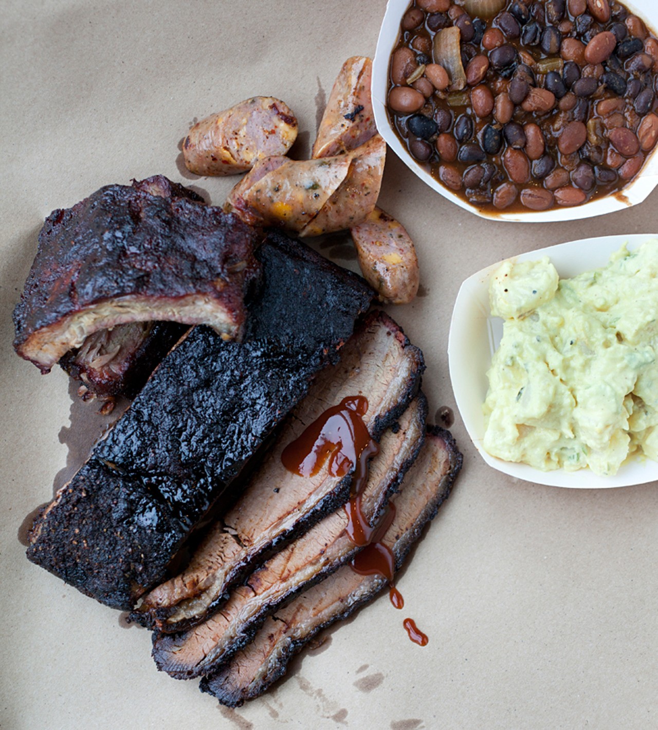 A display of the brisket, baby back ribs, housemade jalapeno sausage, baked beans and potato salad.