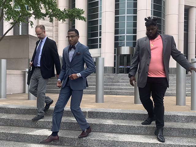 John Collins-Muhammad (center) leaves the federal court building after a hearing in June.
