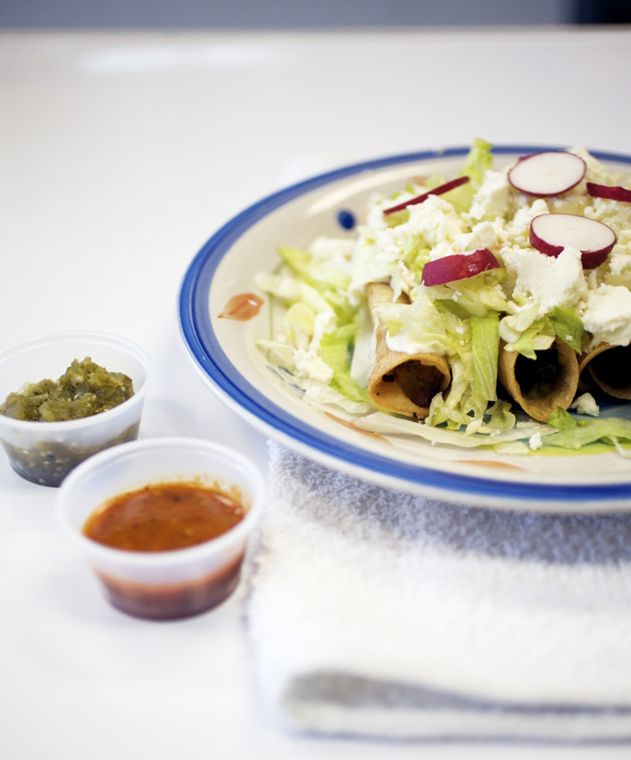 The Flautas are made with corn tortillas and your choice of meat. Here it has been prepared with chicken, and is served with lettuce, queso fresco and radishes.