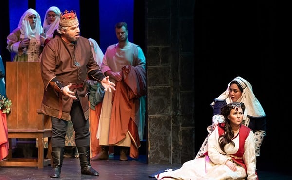 Macbeth (Michael Eugene Nansel, standing left) and Lady Macbeth (Whitney Myers, seated in the foreground) set off a murder spree in Macbeth.