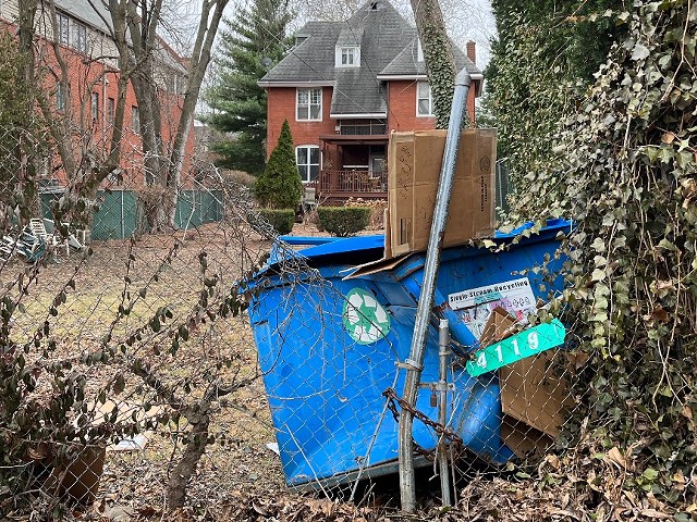 An early morning fiery car crash sent this recycling dumpster over a fence and into a neighbor's backyard.