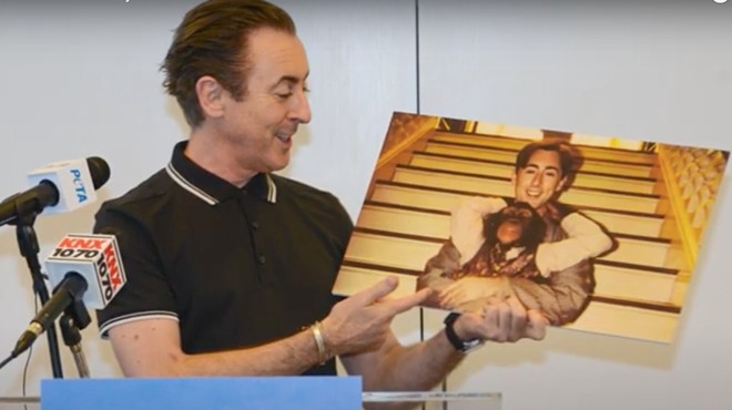 Alan Cumming holding a picture of his erstwhile co-star, Tonka.