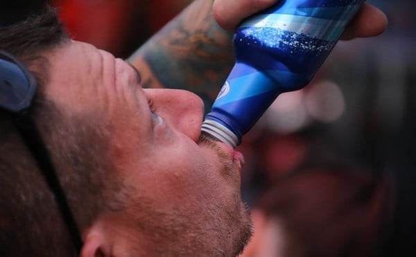 A man drinks Bud Light.
