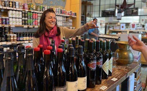 A woman offers a wine tasting at Parker's Table.