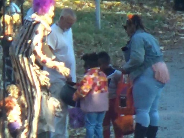 Thomas Sanderson distributing candy to children at home on October 31, 2022.