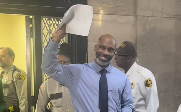 Lamar Johnson greeting supporters, holding in the hand the ruling that freed him from 29 years of wrongful incarceration.