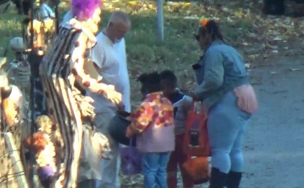 Thomas Sanderson distributing candy to children at home on October 31, 2022.