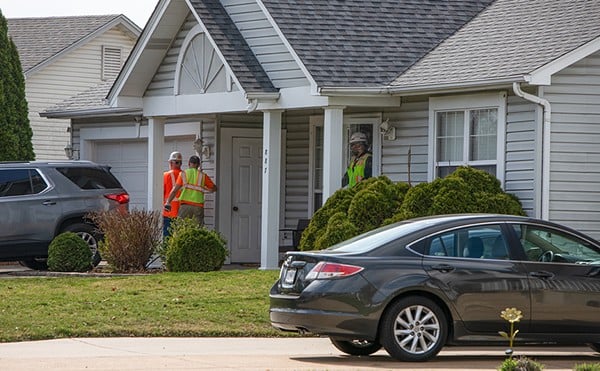 A group of people with the U.S. Army Corps of Engineers exit a home on Cades Cove on Monday, March 4, 2024, in Florissant. The Corps was drilling into the foundation of the house to test soil for radioactive material.