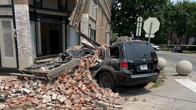The SUV was mashed below a pile of bricks that fell off the building.