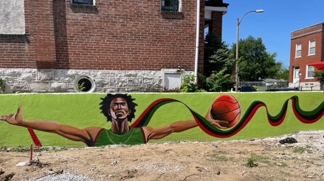 Artist Jamie Bonfiglio's mural of a basketball player with outstretched arms adorns a wall outside a new basketball court nearing completion at 4368 College Avenue.