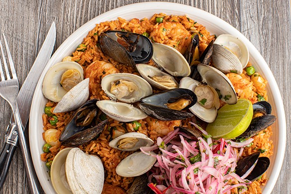 Arroz con mariscos (rice and seafood) with aji panca, garlic rice, shrimp, littleneck clams, pei mussels, peas, cilantro, rocoto and lime.