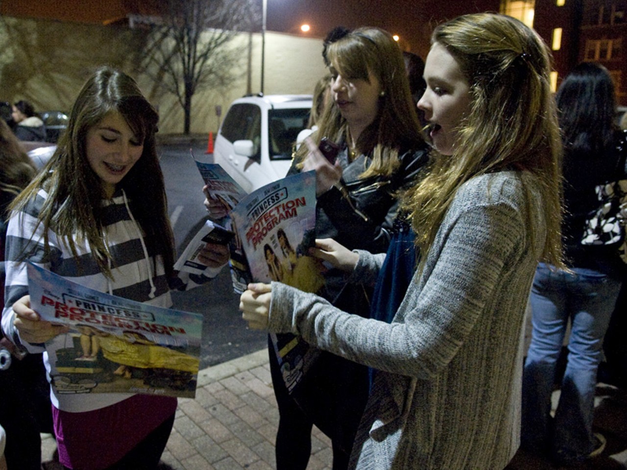Fans hold posters for Princess Protection Program, a 2009 movie by Disney, which also supports Nick Jonas.