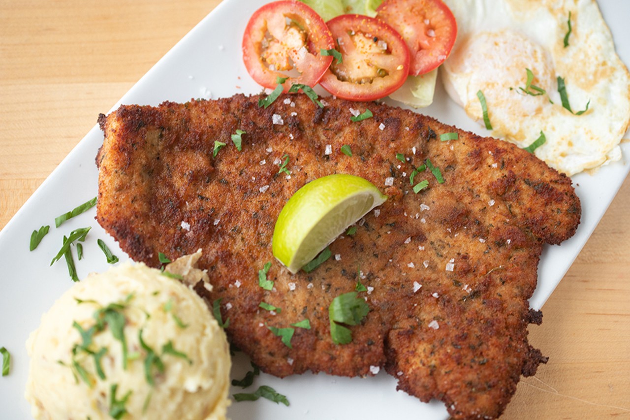 Beef milanesa, or breaded steak filet, with mashed potatoes and fried egg.