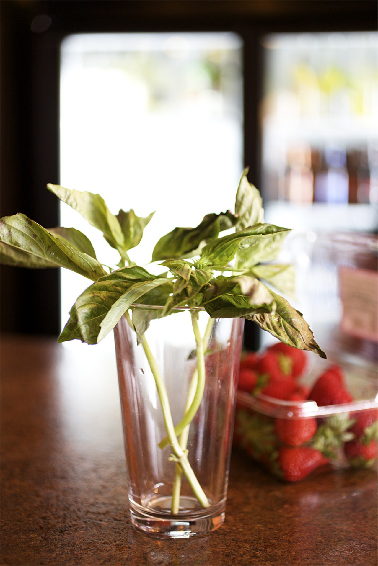 Fresh organic basil and strawberries are out in preparation for Nosh's strawberry basil mojito.