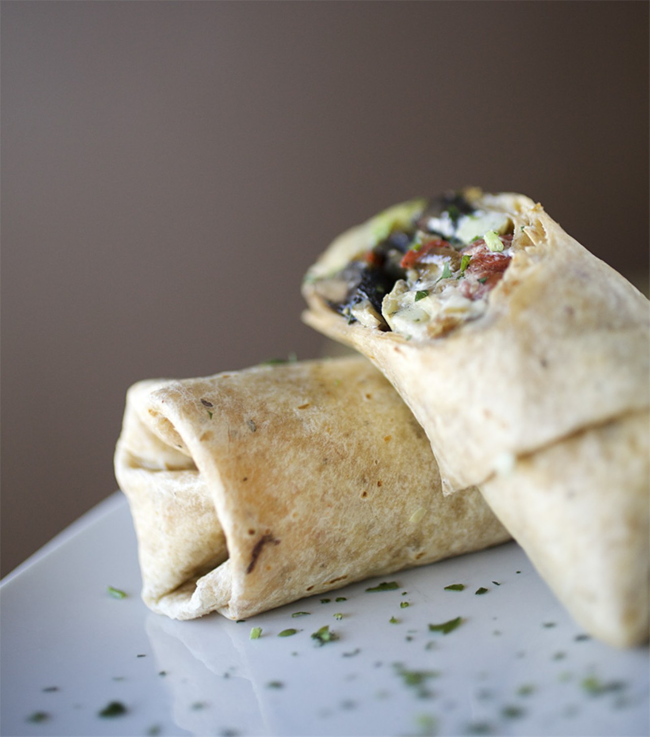 The Portabella Wrap is made with marinated and grilled portabella mushrooms, grilled red peppers, carmelized onion, grilled artichoke hearts, topped with goat cheese and feta blended and then wrapped in a sundried tomato tortilla.