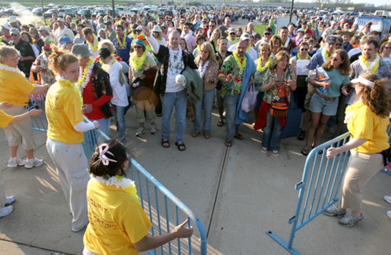 Jimmy Buffett fans patiently wait to enter as security guards remove barriers.