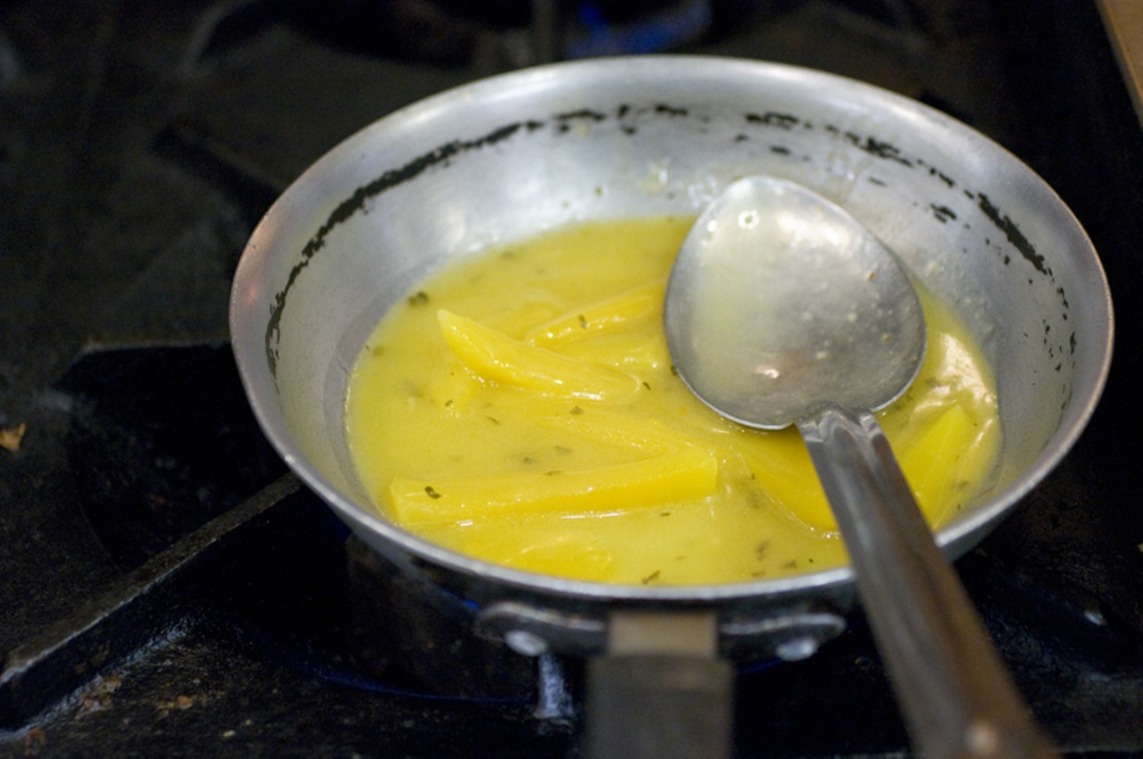 Mango & passion fruit sauce simmers on the stove-top.