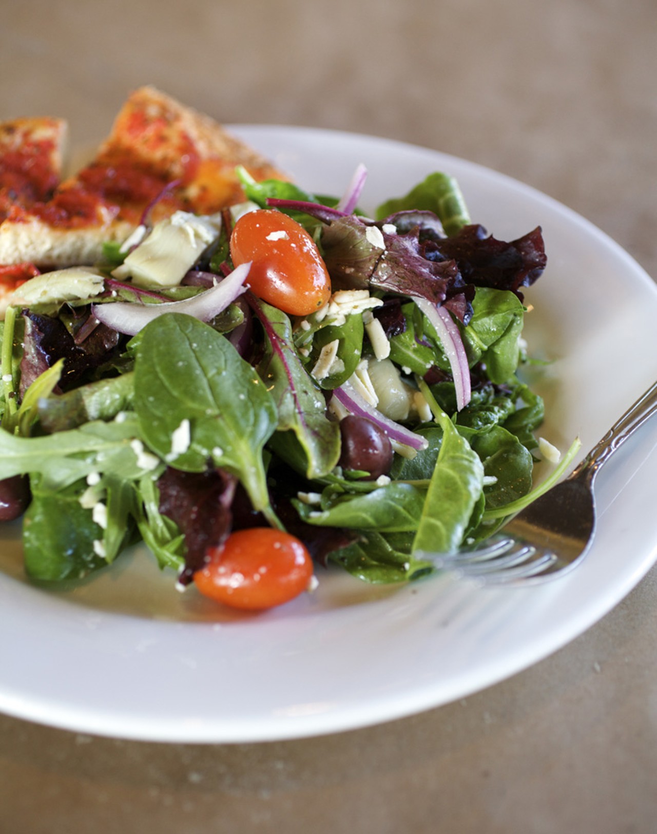 The Tivoli salad is made with mixed greens, red onions, feta cheese kalamata olives, tomatoes and artichokes.