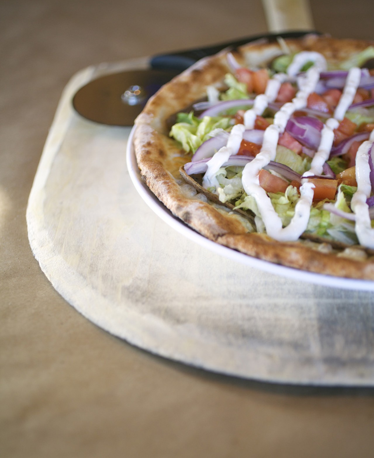 The Villa D'Este is a gyro pizza made with gyro meat, olive oil, feta, tomatoes, red onions, lettuce and tzaziki sauce.