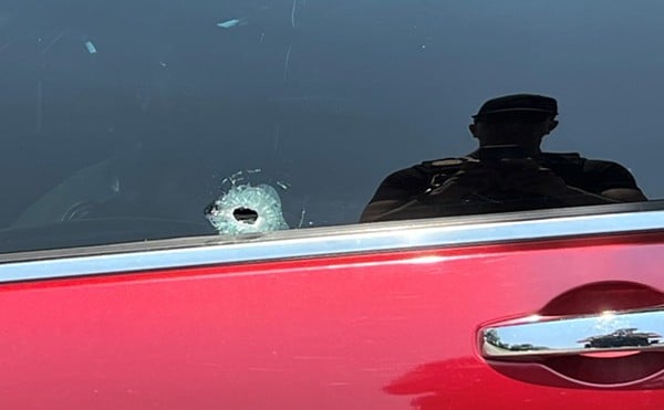 Bullet holes in an unmarked police car.
