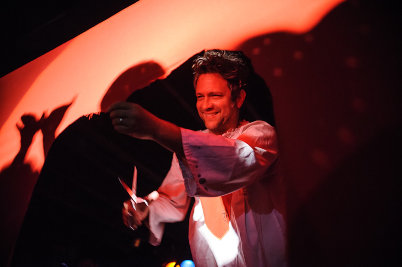 Tim DeLaughter, cutting scraps from The Polyphonic Spree's red curtain.
