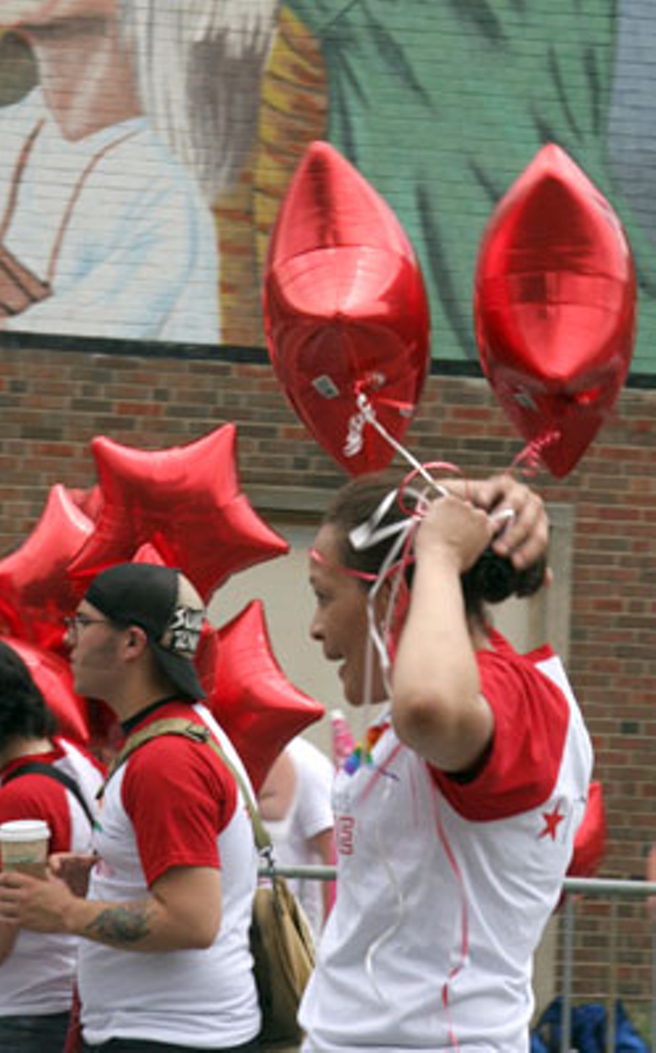 A woman representing Macy's department store ties balloons to her ponytail.